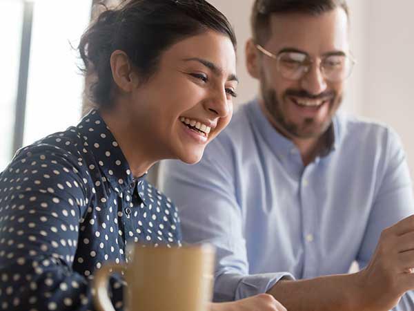 two associates smiling as they work together