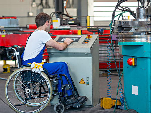 man in a wheelchair operating an industrial machine