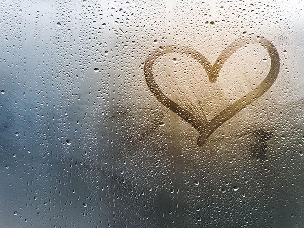 a heart drawn on a misty foggy window