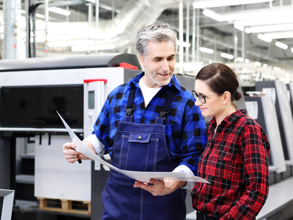 male worker reviewing printing proof with woman coworker
