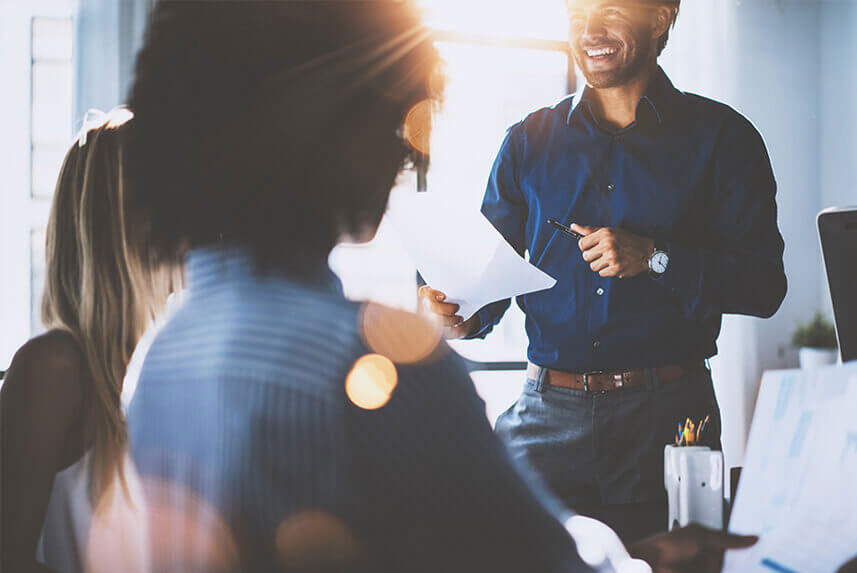 Man reading notes in team meeting