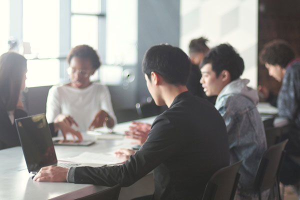 Various ethnic young people working in a modern share office