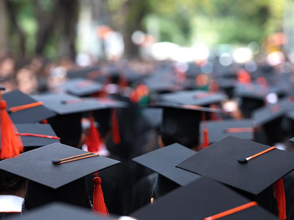 shallow-focus photo of a crowd of graduates in their caps and gowns