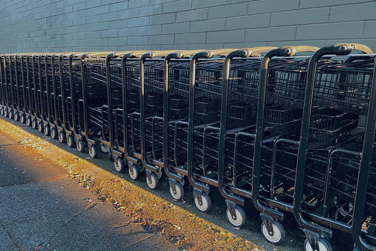 shopping carts lined up against a gray brick wall