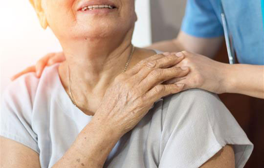 Healthcare worker with a hand on a patient's shoulder
