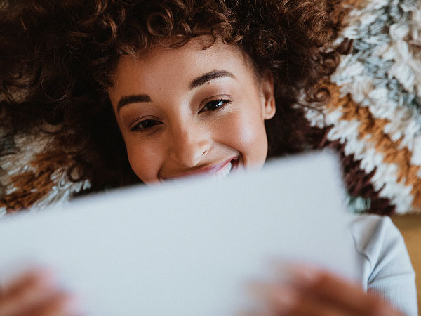 Happy woman engaging with direct mail.