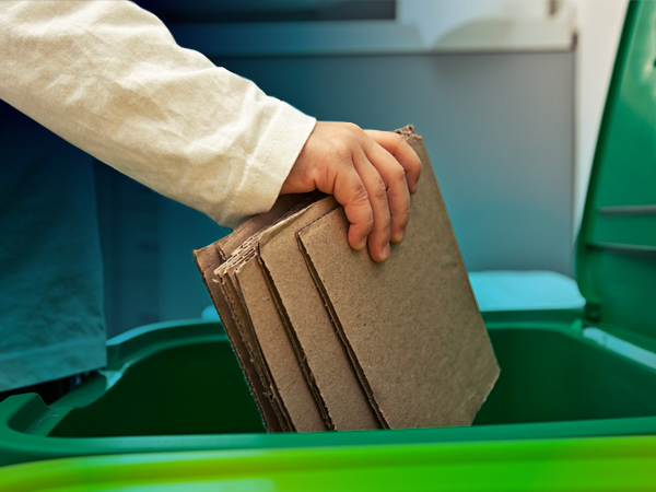 reducing packaging waste and an image of a person placing flattened packaging into a recycling bin.