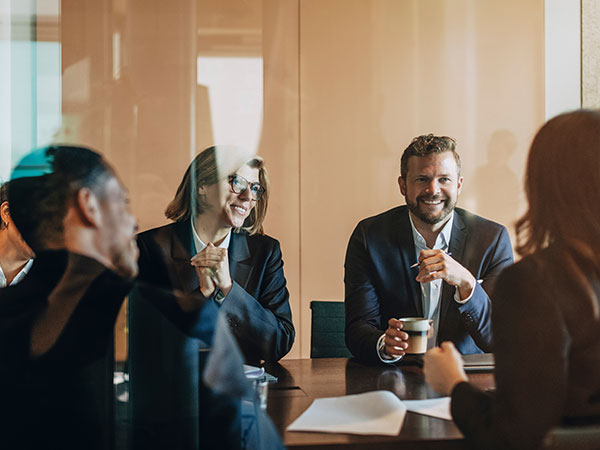 executives smiling around a conference table