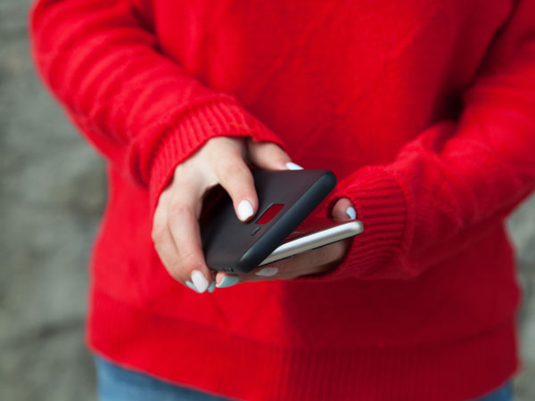 a woman in red holding a cell phone and it's case