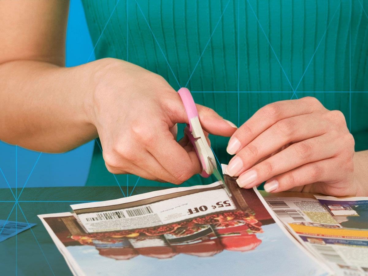 woman clipping a coupon from a circular