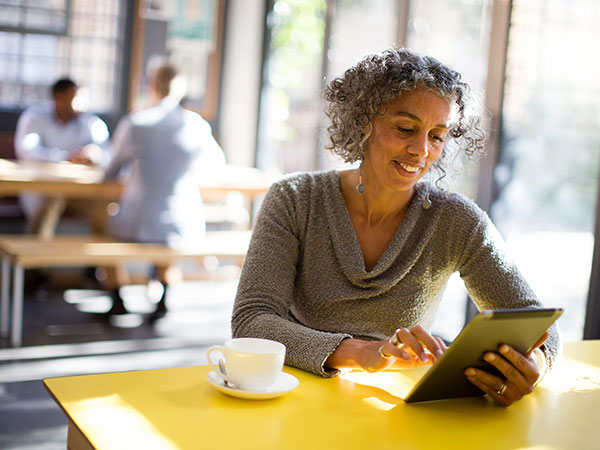 Woman working on tablet at coffee shop