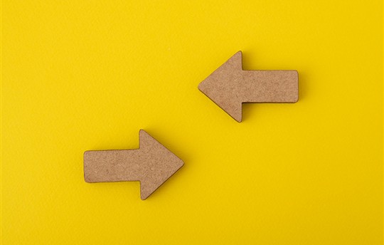 two arrows pointing at each other on a yellow background