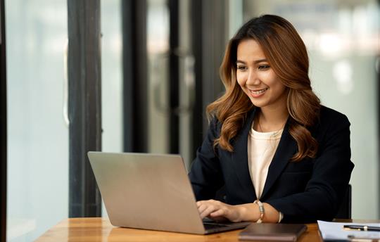 asian woman in using laptop in her office