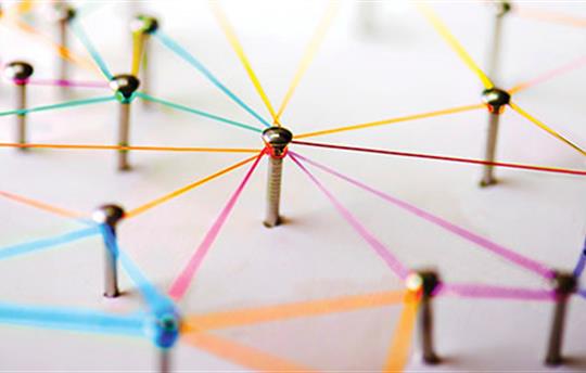 pins through a piece of paper with colorful threads connecting them