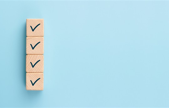 stacked wooden blocks with checkmarks on them