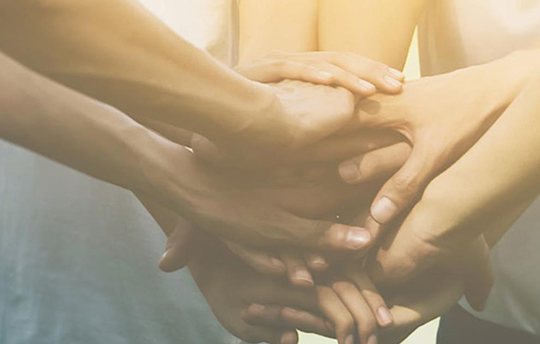 hands of many people clasped together