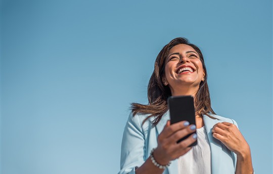 woman holding phone and smiling